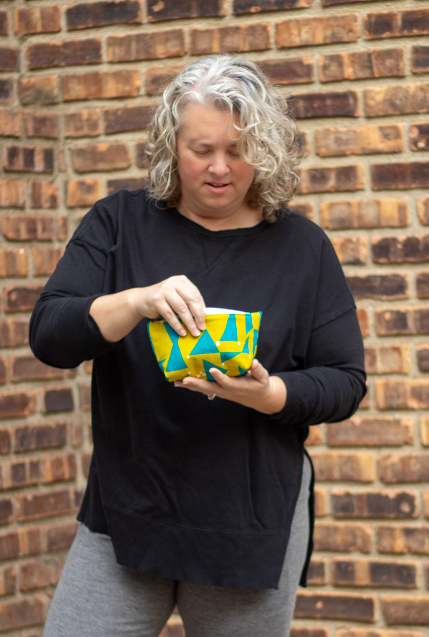 Image of yellow and blue Rivet Patterns Prelude Pouch being held